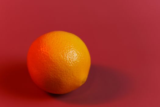 Orange fruit with red background.