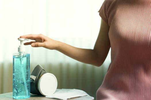 Respirator masks and hand sanitizer gel, woman hand using sanitizer gel for Coronavirus corona virus prevention (PPE)