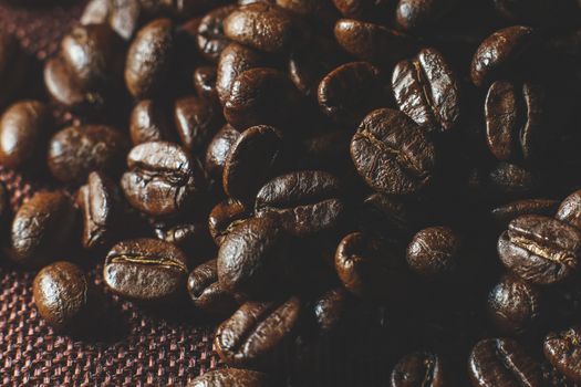 Roasted coffee beans pile on burlap