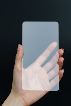 Hand holding and showing transparent smartphone. Business, technology concept.