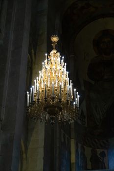 The Svetitskhoveli Cathedral, Mtskheta Georgia 05/10/2019 beautiful interior image looking up to the central central candelabra with murals and icons.