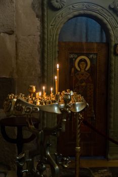 The Svetitskhoveli Cathedral, Mtskheta Georgia 05/10/2019 beautiful interior image with votive candles and with murals and icons.