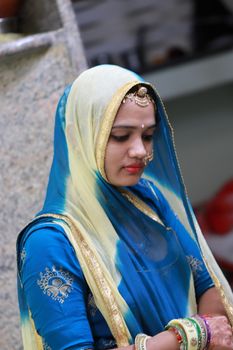 A beautiful North India girl and wearing a gold embellishment with a bright yellow and sky colored dress.