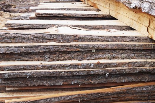 unedged lumber, stacked open air close-up