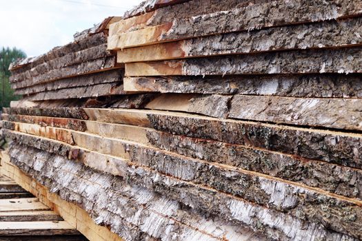 unedged lumber, stacked open air close-up