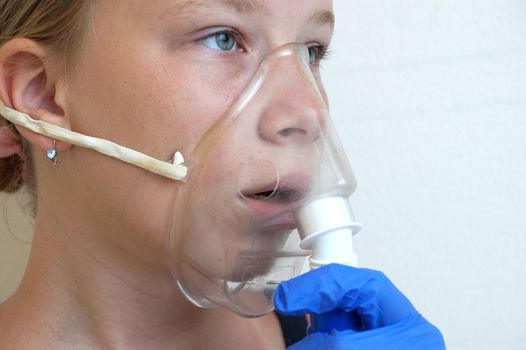 girl breathing through an inhaler, portrait close-up