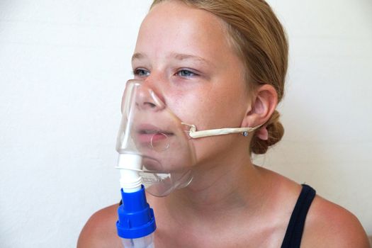 girl breathing through an inhaler, portrait close-up