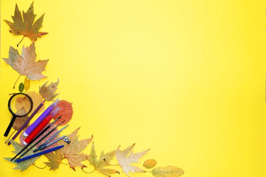 school stationery and autumn leaves on a yellow background, copy space, mockup blank