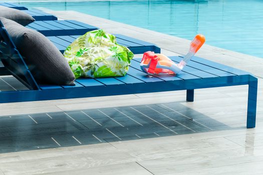 Swimming pool with chaise loungers background