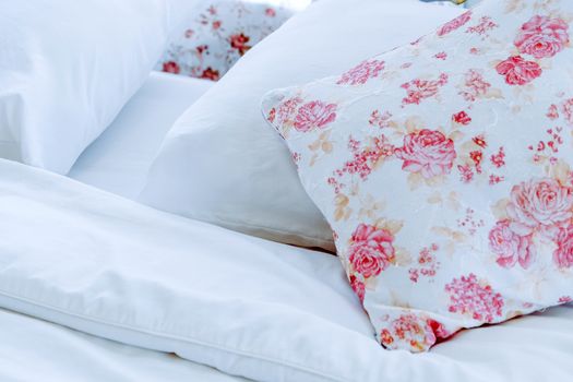 Bright bedroom interior with flower pattern pillows on bed