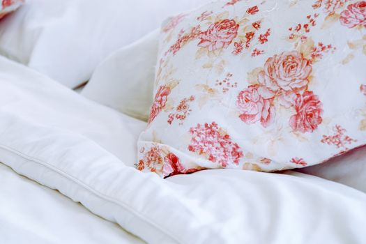 Bright bedroom interior with flower pattern pillows on bed