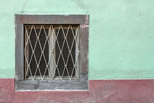 An old window on a facade painted with unusual colors.