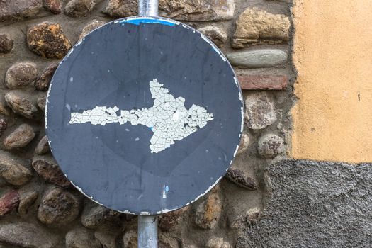 An old direction signal ravaged by time.