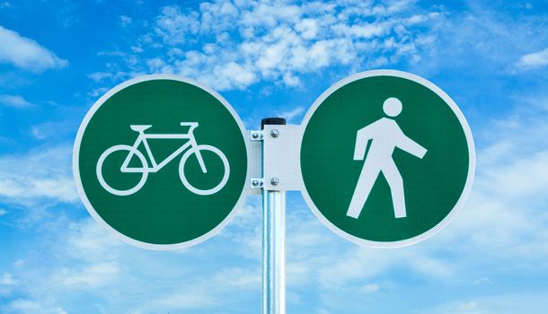 Bicycle and pedestrian shared route sign on cloudy sky background