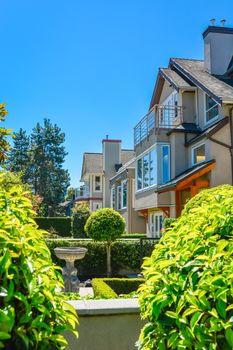 Front of houses with landscaped yard on sunny day