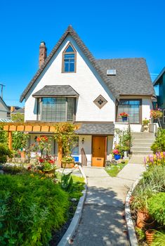 Old style family house with landscaped front yard and concrete pathway to the entrance