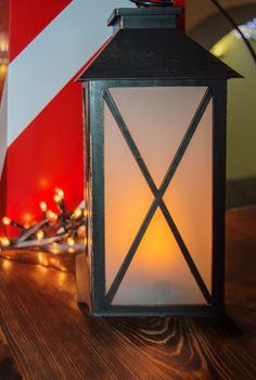 Christmas decoration on a dark background, a magic illuminated lantern and a colorful bokeh of garlands. Christmas decorations and new year mood, vertical frame.