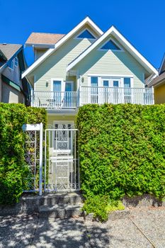 Residential house with entrance gate and green hedge in front