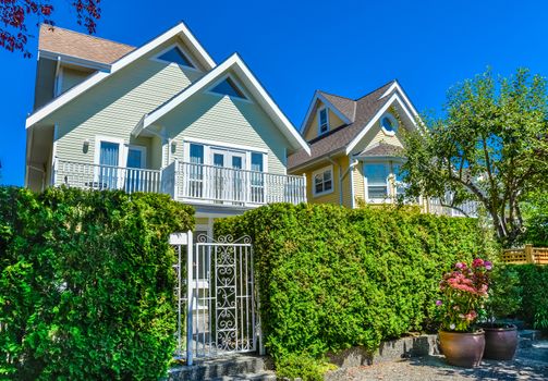 Residential house with entrance gate and green hedge in front