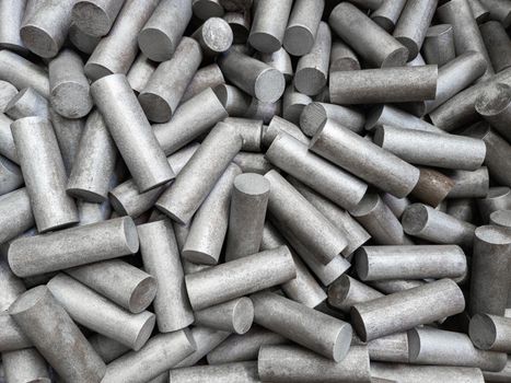 a pile of sand blasted stainless steel rods - closeup with selective focus and blur.