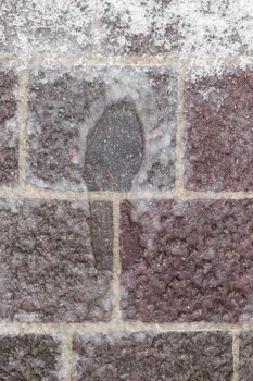 An imprint of the shoe in the icy snow.