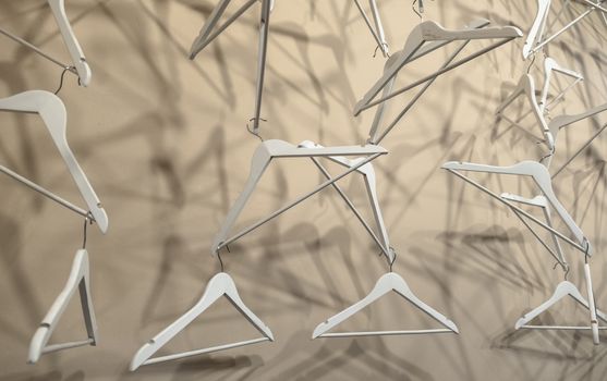 Empty wooden clothes hangers casting deep shadows. Real coat hanger wood pattern. Abstract fashion concept.