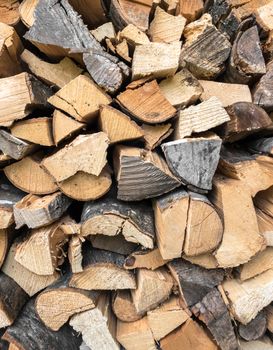 Background of dry chopped firewood. Stock pyre dry for fuel. They use for cook and make heat when cold weather.