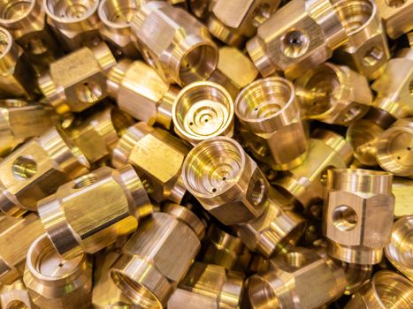 shiny brass parts background, chaotic disorder pile in close-up view with selective focus and dreamy blur.