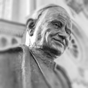 Statue of Pope John XIII in Bergamo, Italy. Selected focus. Defocused blurry background.