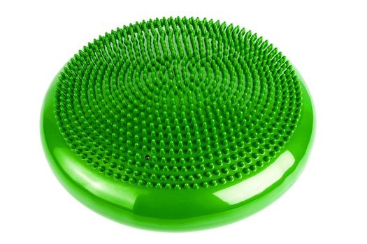 Green inflatable balance disk isoleated on white background. A balance disk is a cushion can be used in fitness training as the base for core, balance, and stretching exercises. It is also known as a stability disc, wobble disc, and balance cushion.