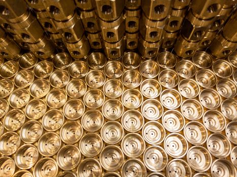 an abstract industrial close-up background of shiny brass metal threaded hexagonal fitting parts.