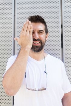 Bearded guy with sunglasses gesturing while looking at camera