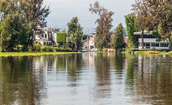 Landscape of the Cuemanco canal in Xochimilco, Mexico City. Calm river. Trajineras. Xochimilco. CDMX. The river flows in spring through the woods