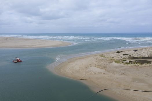 Aerial view of a sand dredger boat at the mouth of the River Murray in regional Australia