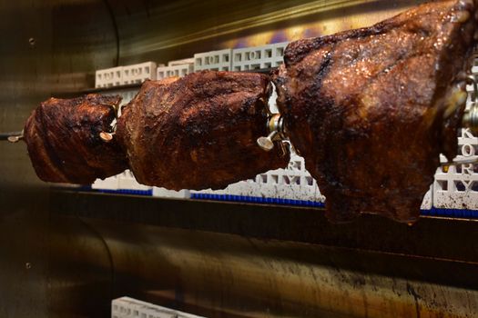 Three Well-Done Racks of Ribs Inside a Rotisserie