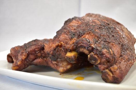 A Well-Done Rack of Ribs Plated on a White Background