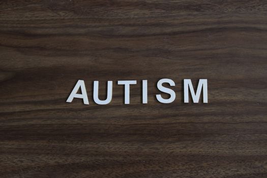 the word autism spelled out on a wooden background. High quality photo