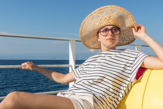 Beautiful, romantic blonde woman relaxeing on summer vacations traveling by cruse ship ferry boat. Summer vacation lifestyle.