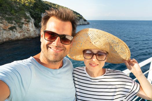 Beautiful, romantic caucasian couple taking selfie self portrait photo on summer vacations traveling by cruse ship ferry boat. Relaxed cheerful lifestyle couple selfie.