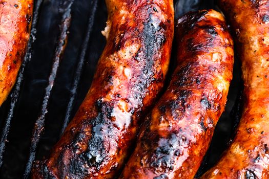 Close up on details of homemade sausages on barbecue grill. Barbecue, grill and food concept.