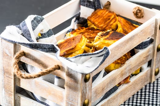 Freshly baked homemade ham and cheese puff pastry in a rustic crate.