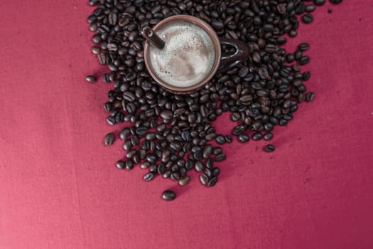 Cup of coffee, roasted coffee beans on red background, top view, copy space for text, coffee concept, close up coffee photo