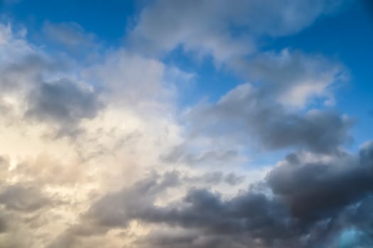 Beautiful panorama of orange and yellow clouds at sunrise and sunset in a blue sky