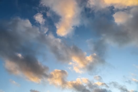 Beautiful panorama of orange and yellow clouds at sunrise and sunset in a blue sky