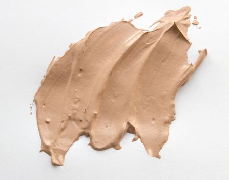 Liquid beige Foundation smeared on a white background.