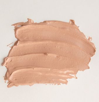 Liquid beige Foundation smeared on a white background.