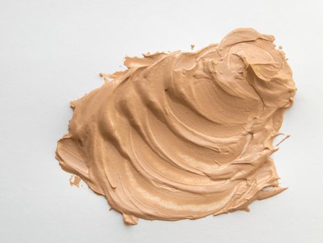 Liquid beige Foundation smeared on a white background.