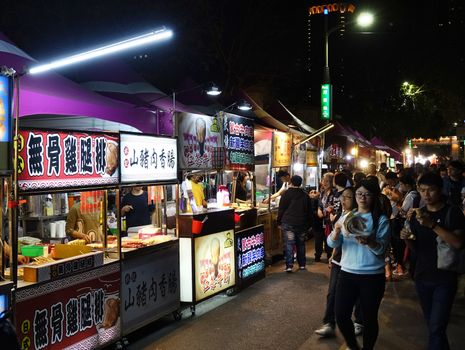 KAOHSIUNG, TAIWAN -- MARCH 2, 2018: Visitors flock to a night market with a large variety of food stalls.
