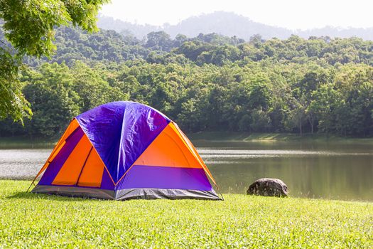 Tourist dome tent camping in forest camping site at lake side