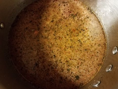 seasoned hot broth liquid in metal pan or pot